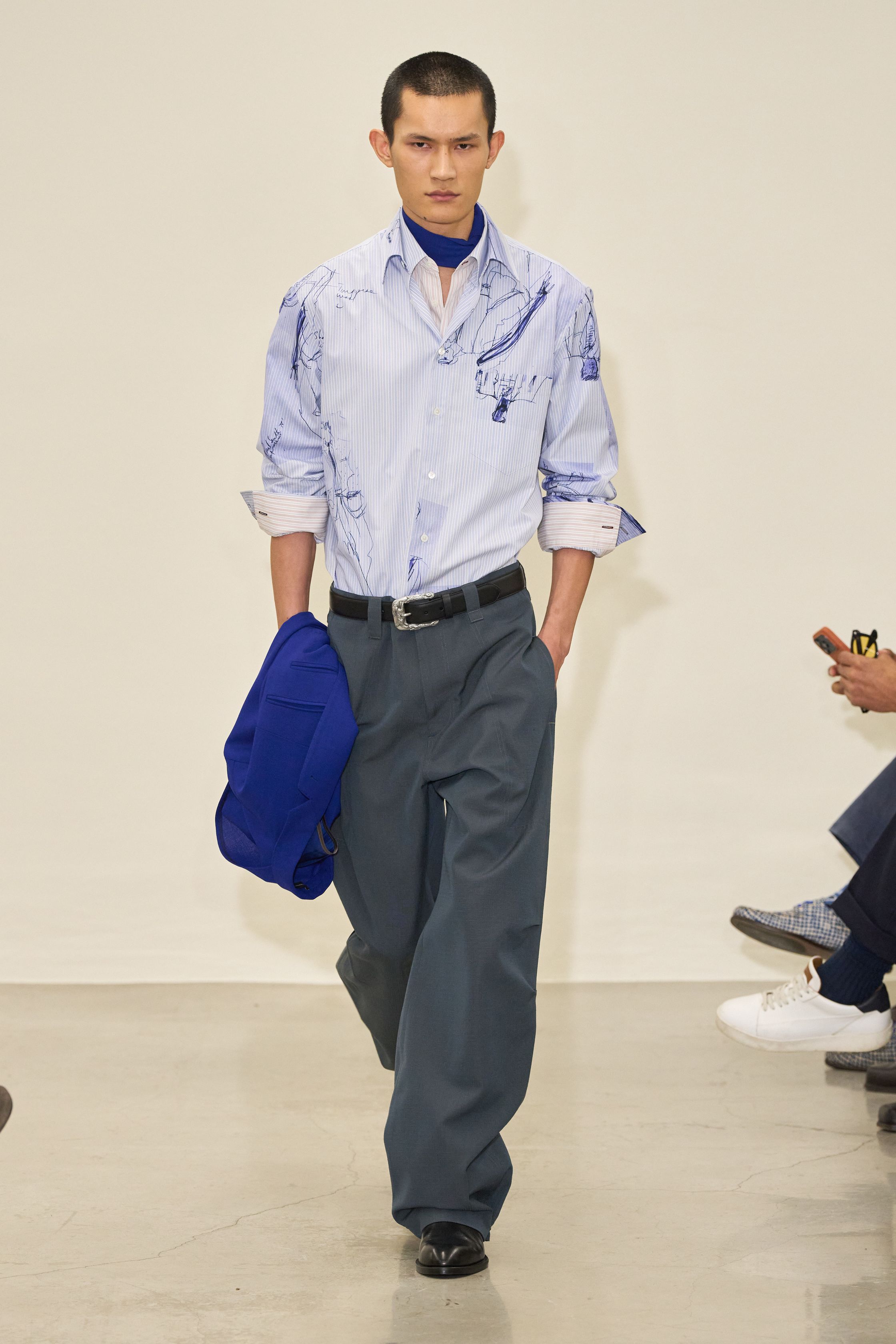 Paul Smith 2026秋冬回归品牌最具识别度的“英式日常诗意”。系列以传统剪裁为骨架，却通过色彩点缀、围巾叠搭与比例微调，赋予男装更松弛的情绪温度。西装不再严肃，风衣与大衣在肩线与长度上释放空间，搭配针织与衬衫形成轻度混搭。整体传递的是一种文化型男性的穿衣态度——不追逐潮流，却始终保持幽默感与个人风格-顽石频道趋势研究